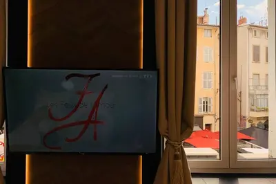 a book sitting next to a window with a view of a building at Suite Le CEZANNE in Aix-en-Provence