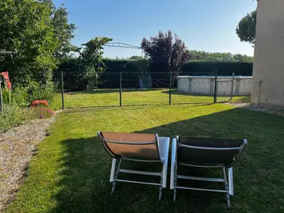 a chair sitting on the grass in a yard at L’ escapade in Mallemort