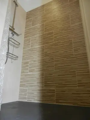 a stone wall in a bathroom with a wooden wall at L’ escapade in Mallemort