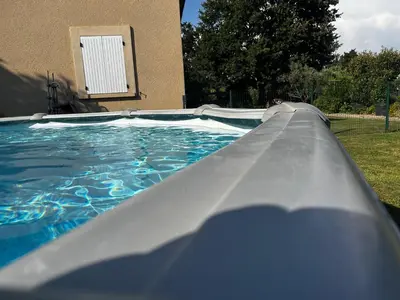 a slide in a swimming pool in front of a house at L’ escapade in Mallemort