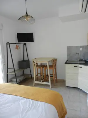 a bedroom with a table and a kitchen with a bed at L’ escapade in Mallemort