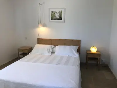 a bedroom with a white bed with two night stands at Chambre hôtes Les Garrigues CUCURON in Cucuron