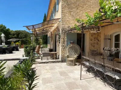 a patio with chairs and tables and a building at Bastide provençale à Murs, coeur du Lubéron in Murs