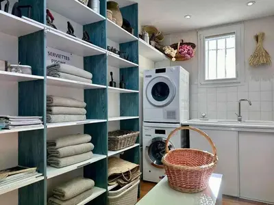 a laundry room with white shelves and a washing machine at Bastide provençale à Murs, coeur du Lubéron in Murs