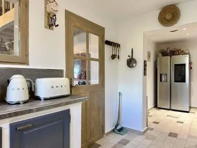 a kitchen with a counter and a refrigerator at Bastide provençale à Murs, coeur du Lubéron in Murs