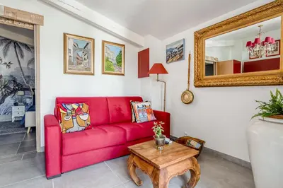 a living room with a red couch and a table at Le Parc in Carpentras