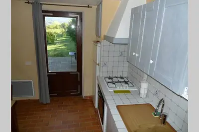 a kitchen with a sink and a stove and a window at Le Tilleul in Lacoste