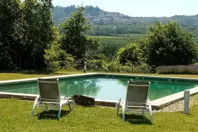 two chairs sitting in front of a swimming pool at Le Tilleul in Lacoste