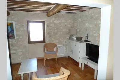 a living room with a television and a table and chairs at Le Tilleul in Lacoste