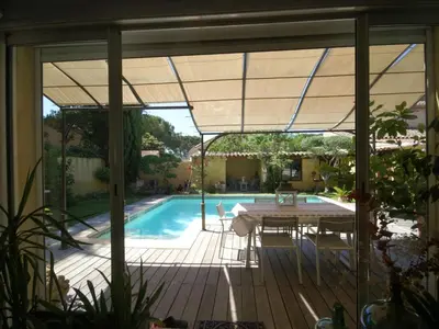 a patio with a table and a swimming pool at Le Cezanne in Aix-en-Provence
