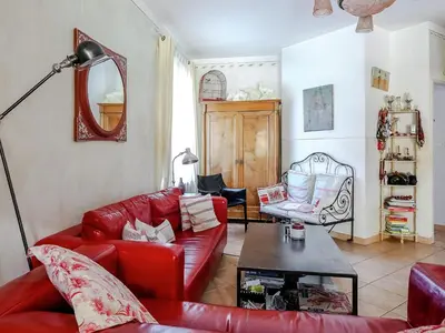 a living room with red couches and a table at Le Cezanne in Aix-en-Provence