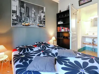 a bedroom with a blue and white bed with pillows at Le Cezanne in Aix-en-Provence