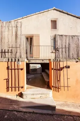 a building with two iron gates in front of it at La maison de Gaston au cœur du Luberon in Villars
