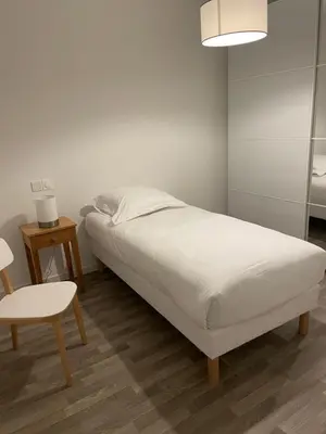 a bedroom with a bed and a table and a chair at DOMITYS LES TOURMALINES in Carpentras