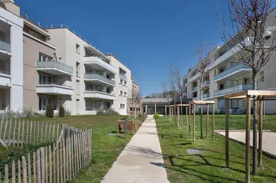 an apartment building with a playground in front of it at DOMITYS LES TOURMALINES in Carpentras