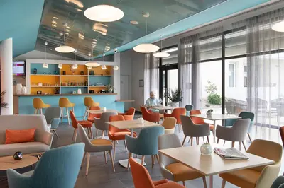 a restaurant with tables and chairs and a person in the background at DOMITYS LES TOURMALINES in Carpentras