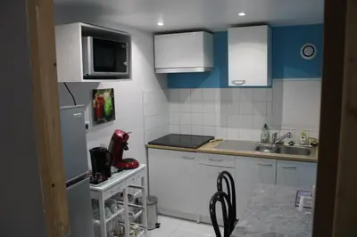 a small kitchen with white cabinets and a sink at les lauriers de Joelle in Peyrolles-en-Provence