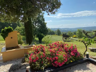 a garden with pink flowers and a bench in a field at Location bastide provencale Luberon in Murs