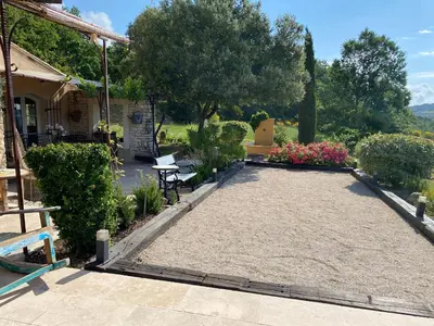 a patio with flowers and a bench in a yard at Location bastide provencale Luberon in Murs