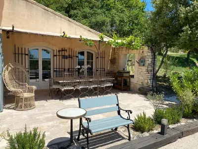 a blue bench sitting on a patio with a table at Location bastide provencale Luberon in Murs