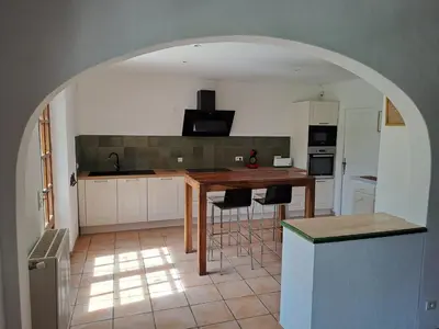 a kitchen with a table and some chairs in it at LA LEZARDIERE CHEZ HUGUES in Saint-Rémy-de-Provence