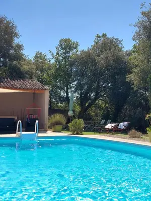 a large blue swimming pool in front of a house at Maison d'Hôtes & Spa La Chêneraie-Provence Ventoux in Saint-Didier
