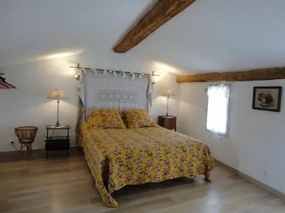 a bedroom with a bed and two lamps and a window at LOlivier sur le Toit in LʼIsle-sur-la-Sorgue
