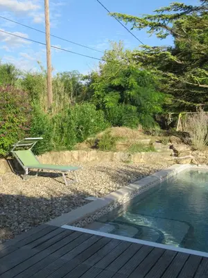 a pool with a bench and a chair next to it at LA MASTRONA in Saumane-de-Vaucluse