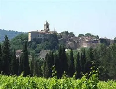 a town on a hill with trees and a building at A l’ombre du géant de Provence in Mormoiron