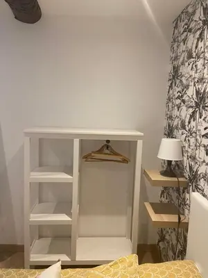 a white book shelf in a room with a lamp at A l’ombre du géant de Provence in Mormoiron