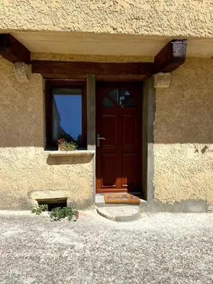 a red door of a building with a window at A l’ombre du géant de Provence in Mormoiron