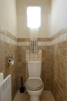 a bathroom with a white toilet and a window at La Petite Maison - Mas des Sous Bois in Ventabren