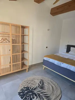 a bedroom with a bed and a rug at Un petit coin de Bali avec SPA et piscine privés in Carpentras