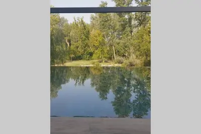 a view of a lake through a window at Un petit coin de Bali avec SPA et piscine privés in Carpentras
