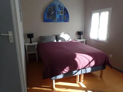 a bedroom with a bed with a purple blanket at Gîte de l'ASPA in Saint-Christol