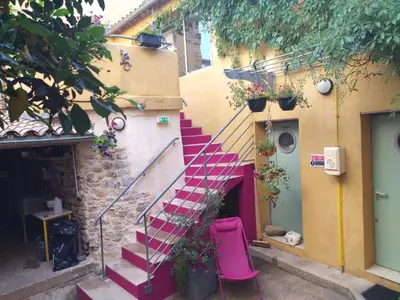 a staircase in a building with a pink stair case at Gîte de l'ASPA in Saint-Christol