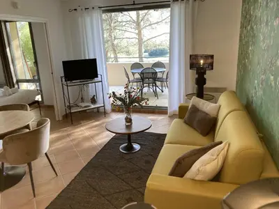 a living room with a yellow couch and a table at LA PERLE DE PROVENCE-Magnifique Vue CLIM LINGE Golf Saumane 6P Piscine Tennis in Saumane-de-Vaucluse