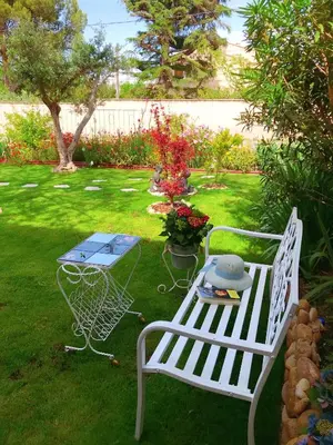 a white bench and a table in a yard at La Maison du Chemin des Prairies in Morières-lès-Avignon