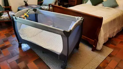 a baby crib in a room with a bed at La Maison du Chemin des Prairies in Morières-lès-Avignon