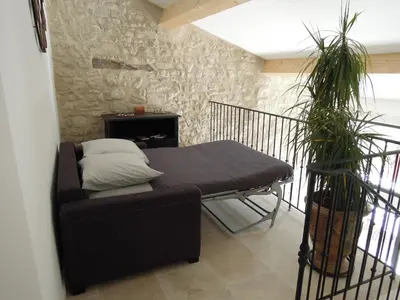 a living room with a couch and a stone wall at La Bourgade in Céreste