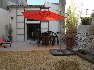 a red umbrella on a patio with a table at La Bourgade in Céreste