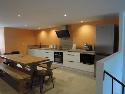 a kitchen with a wooden table and a refrigerator at La Bourgade in Céreste