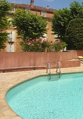 a swimming pool with two metal rails in front of a building at Appartement de charme au calme avec piscine, au pied du Colorado provençal, cœur du Luberon in Rustrel