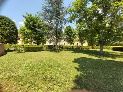 a yard with trees and a building in the background at Appartement de charme au calme avec piscine, au pied du Colorado provençal, cœur du Luberon in Rustrel