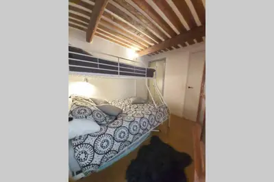 a bedroom with a bunk bed with blue and white pillows at Appartement de charme au calme avec piscine, au pied du Colorado provençal, cœur du Luberon in Rustrel