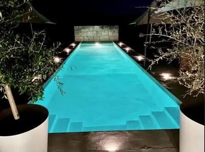 a swimming pool at night with lights at LASUITE Domaine Bertuli, heated Pool, Aircon in Oppède