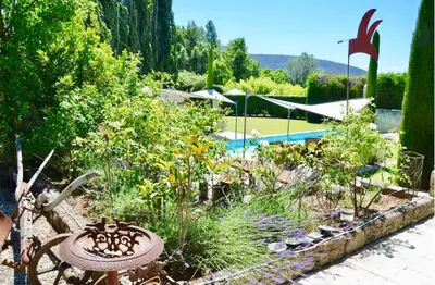 a garden with plants and a swimming pool at LASUITE Domaine Bertuli, heated Pool, Aircon in Oppède
