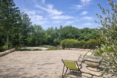two chairs and a table in a yard at Mas de la Chêneraie Blanche, Maison de vacances avec piscine en Luberon in Roussillon