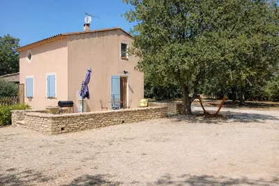 a house with a tree in front of it at Mas de la Chêneraie Blanche, Maison de vacances avec piscine en Luberon in Roussillon