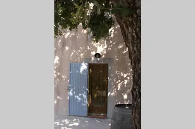 a door in a white building with a tree at Mas de la Chêneraie Blanche, Maison de vacances avec piscine en Luberon in Roussillon